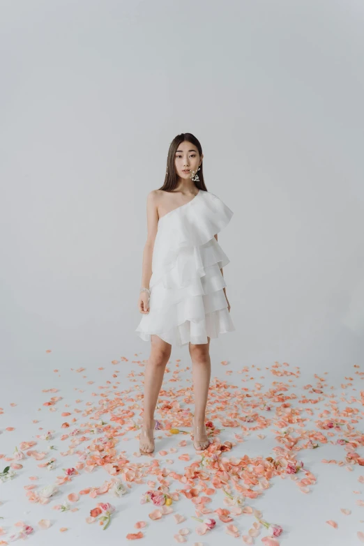 a woman in a white dress surrounded by petals, by Robbie Trevino, wearing toga, ruffles, short dress, heonhwa choe