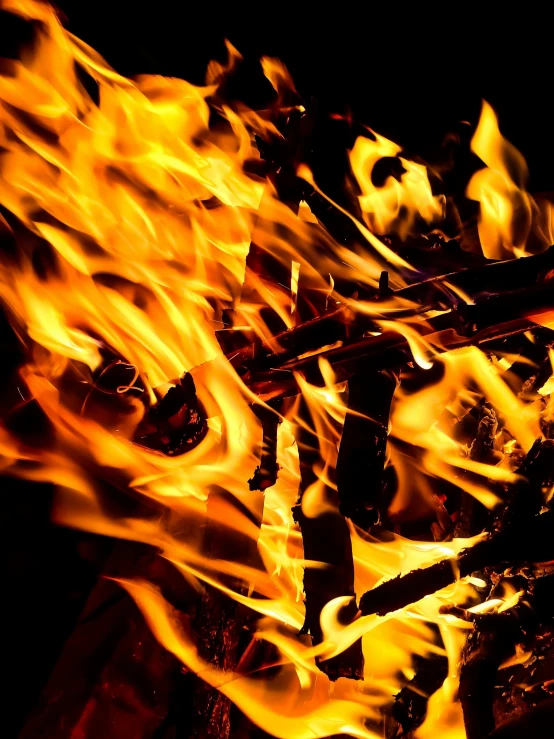 a close up of a fire on a black background, an album cover, pexels, bright orange camp fire, multiple stories, profile pic, full frame image