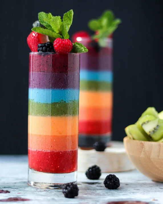 a glass filled with fruit sitting on top of a table, rainbow colors, food, thumbnail, standing upright