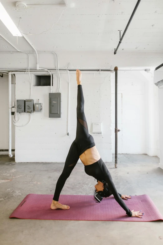 a woman doing a handstand pose on a yoga mat, by Carey Morris, pexels contest winner, dwell, leggings, triangle, low quality photo