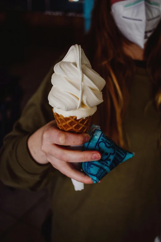 a woman wearing a face mask holding an ice cream cone, inspired by Elsa Bleda, trending on unsplash, blue veins, albino, food, carved soap