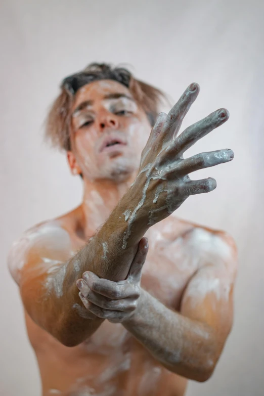 a man that is standing up with his hands in the air, a hyperrealistic painting, inspired by James Barry, trending on pexels, process art, rotting clay skin, covered in white flour, ryan mcginley, frank dillane as puck