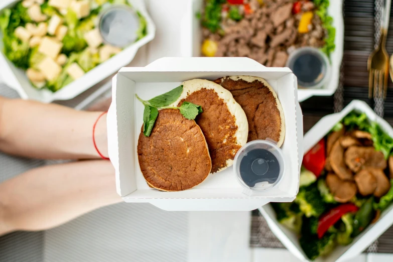 a close up of a person holding a box of food, a picture, dau-al-set, pancakes, greens), product shot, middle eastern