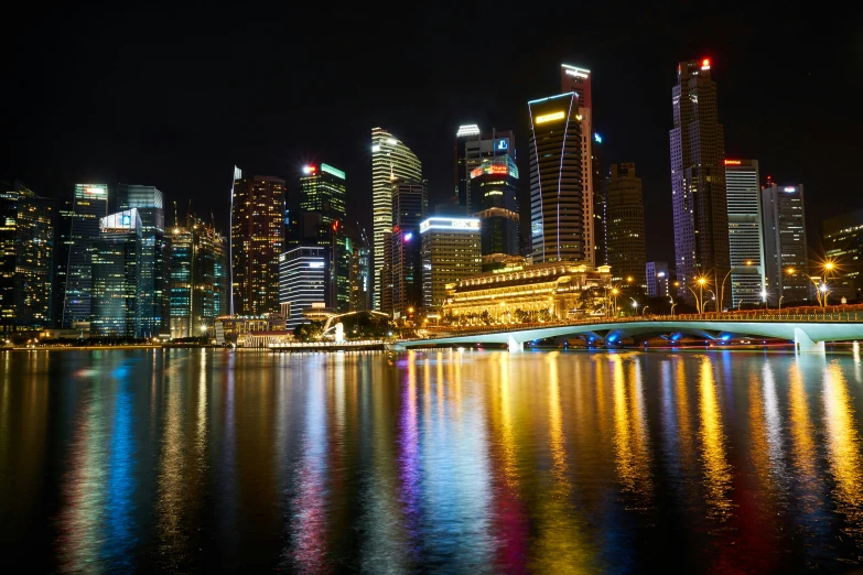 a view of a city at night from across the water, by Patrick Ching, pexels contest winner, avatar image, singapore esplanade, closeup shot, high quality image