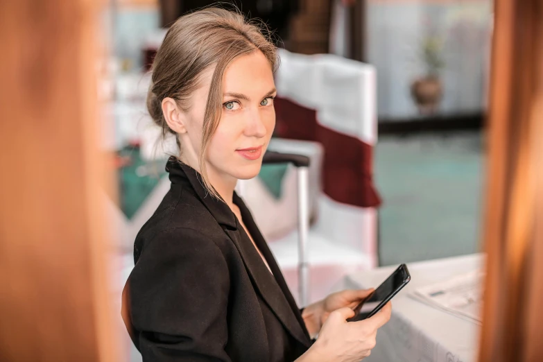 a woman sitting at a table holding a cell phone, sophisticated well rounded face, ukrainian, profile image, multiple stories