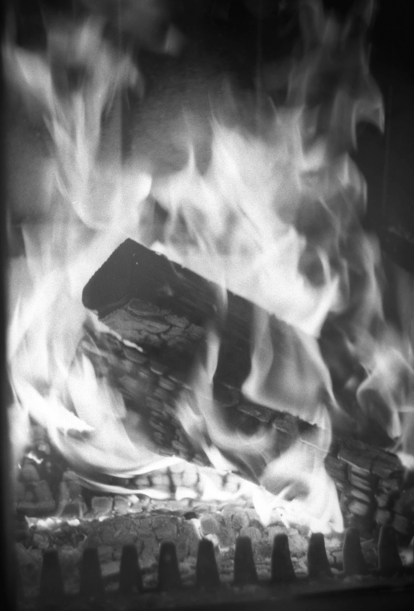 a black and white photo of a fire, a black and white photo, inspired by Germaine Krull, flickr, expired color film, woodfired, 35mm print, warm wood