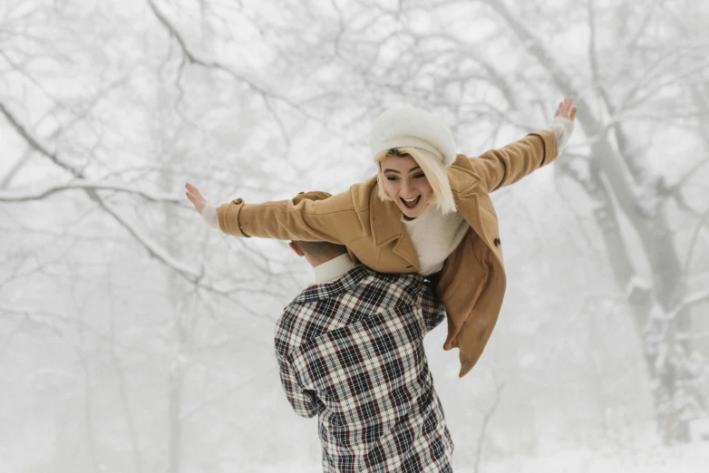 a woman riding on the back of a man on a snowboard, pexels contest winner, visual art, snowy day, smiling and dancing, woman holding another woman, brown