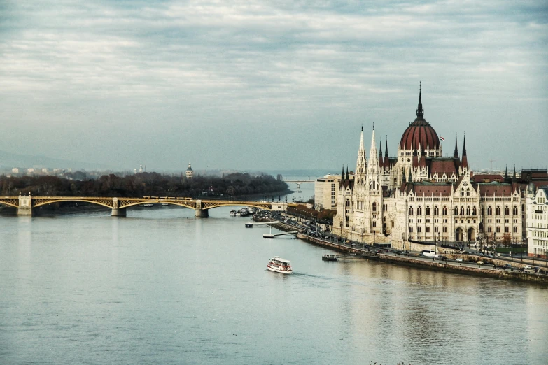 a large building sitting on top of a river next to a bridge, by Matija Jama, pexels contest winner, danube school, spires, panoramic view, 🚿🗝📝, vintage color photo