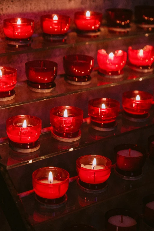 a table topped with lots of red candles, ossuary, vibrant light, shades of red, social media