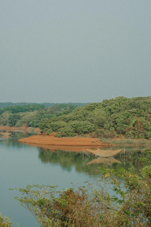 a large body of water surrounded by trees, by Sunil Das, hurufiyya, red sand, water reservoir, aketan