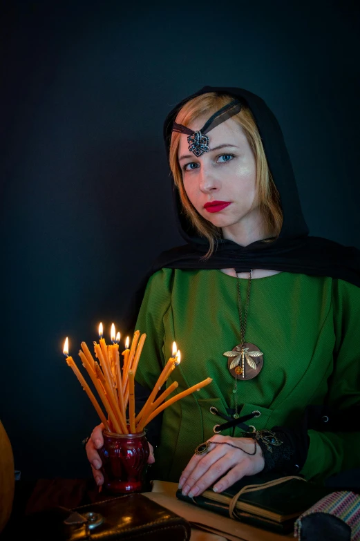 a woman dressed as a witch holding a candle, inspired by Master of the Legend of Saint Lucy, olya bossak, green hood, l critical role, orthodox