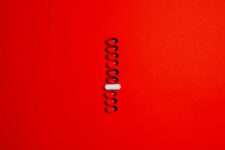 a white pill sitting on top of a red surface, by Elsa Bleda, minimalism, dna helix, red and black details, hook as ring, ocd