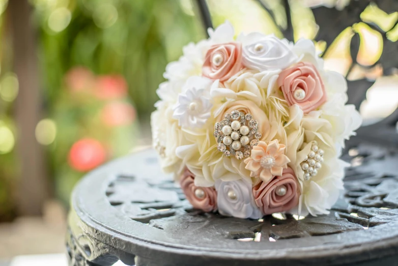 a wedding bouquet sitting on top of a metal table, peach embellishment, fully decorated, full product shot, medium