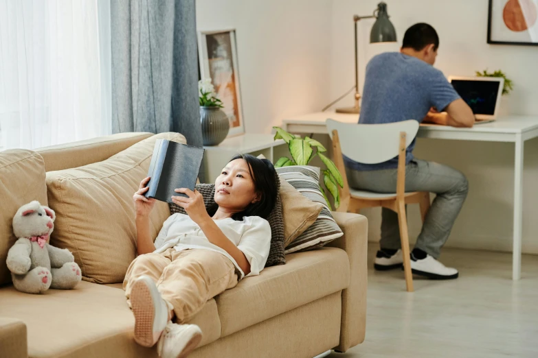 a woman laying on a couch reading a book, happening, ikea, asian male, profile image, full device