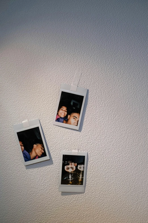 a couple of polaroids hanging on a wall, inspired by Nan Goldin, unsplash, temporary art, having a good time, closeup at the faces, decorations, 2000s photo