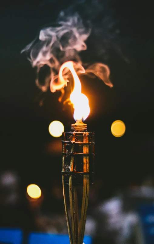 a lit candle sitting on top of a table, holding a torch, liquid smoke, community celebration, gold glow