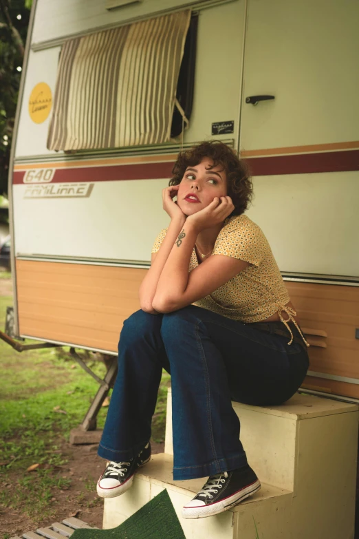 a woman talking on a cell phone next to a camper, inspired by Nan Goldin, pexels, renaissance, sophia lillis, square, aubrey plaza, confident pose