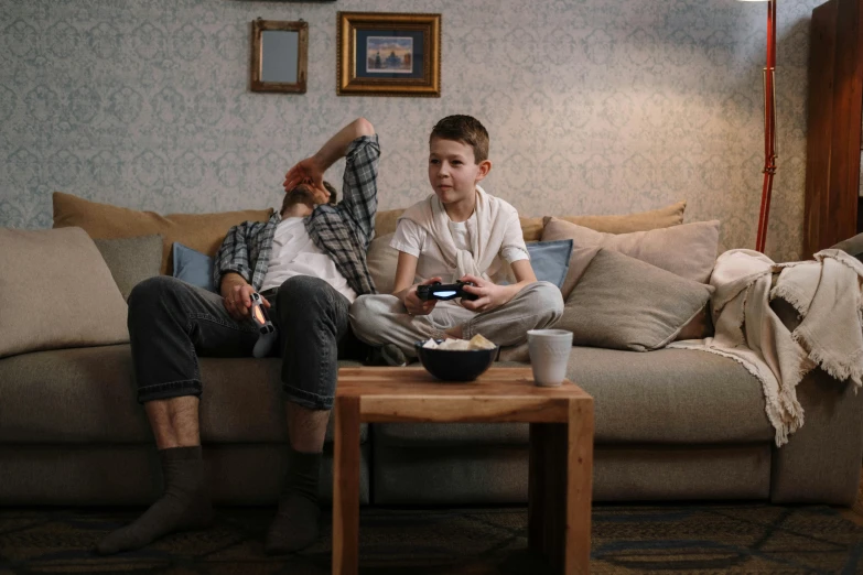 a couple of men sitting on top of a couch, pexels, game ready, kids playing, aged 13, sitting in a lounge