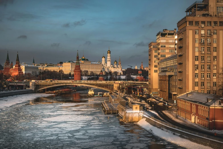 a river running through a city next to tall buildings, an album cover, inspired by Vasily Surikov, pexels contest winner, socialist realism, icy, kremlin, early morning light, brown