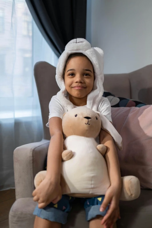 a little girl sitting on a couch holding a stuffed animal, wearing a white bathing cap, pokimane, wearing nanotech honeycomb robe, diverse