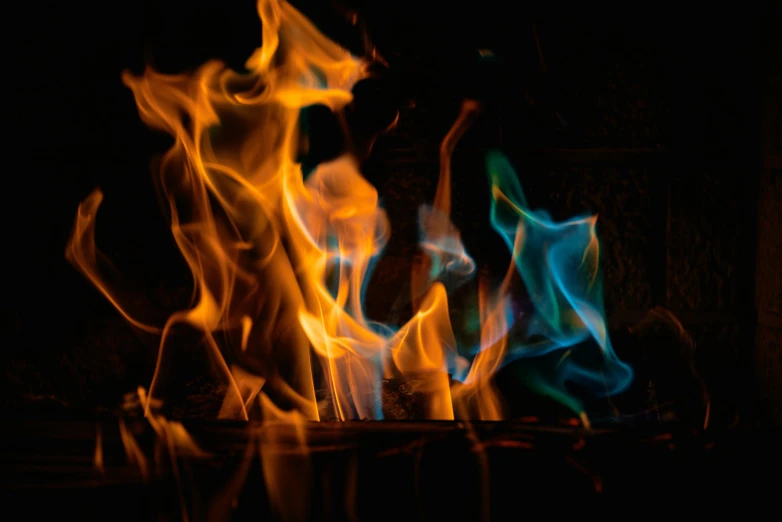 a close up of a fire in the dark, by Jan Rustem, pexels, visual art, in black blue gold and red, avatar image, multicoloured, fireplace