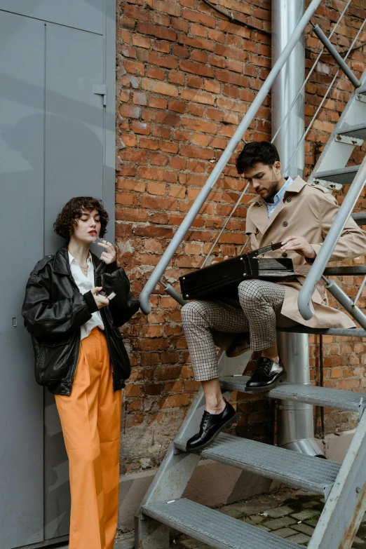 a woman standing next to a man on a set of stairs, by Adam Marczyński, trending on pexels, renaissance, trenchcoat, retro and 1 9 8 0 s style, two young men, developers