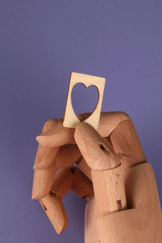 a hand holding a piece of wood with a heart cut out of it, inspired by Grant Wood, new sculpture, mini model, rectangle, strong bespoke shape language, overlooking