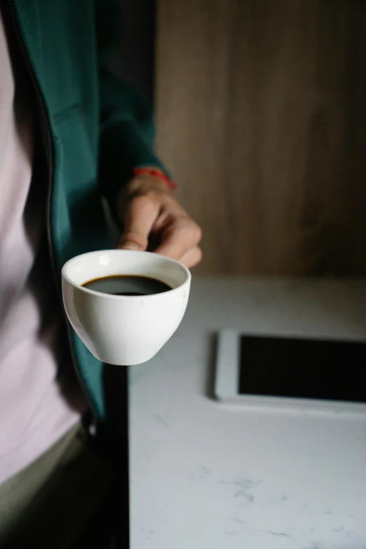 a close up of a person holding a cup of coffee, tech, square, understated, 6 : 3 0 am