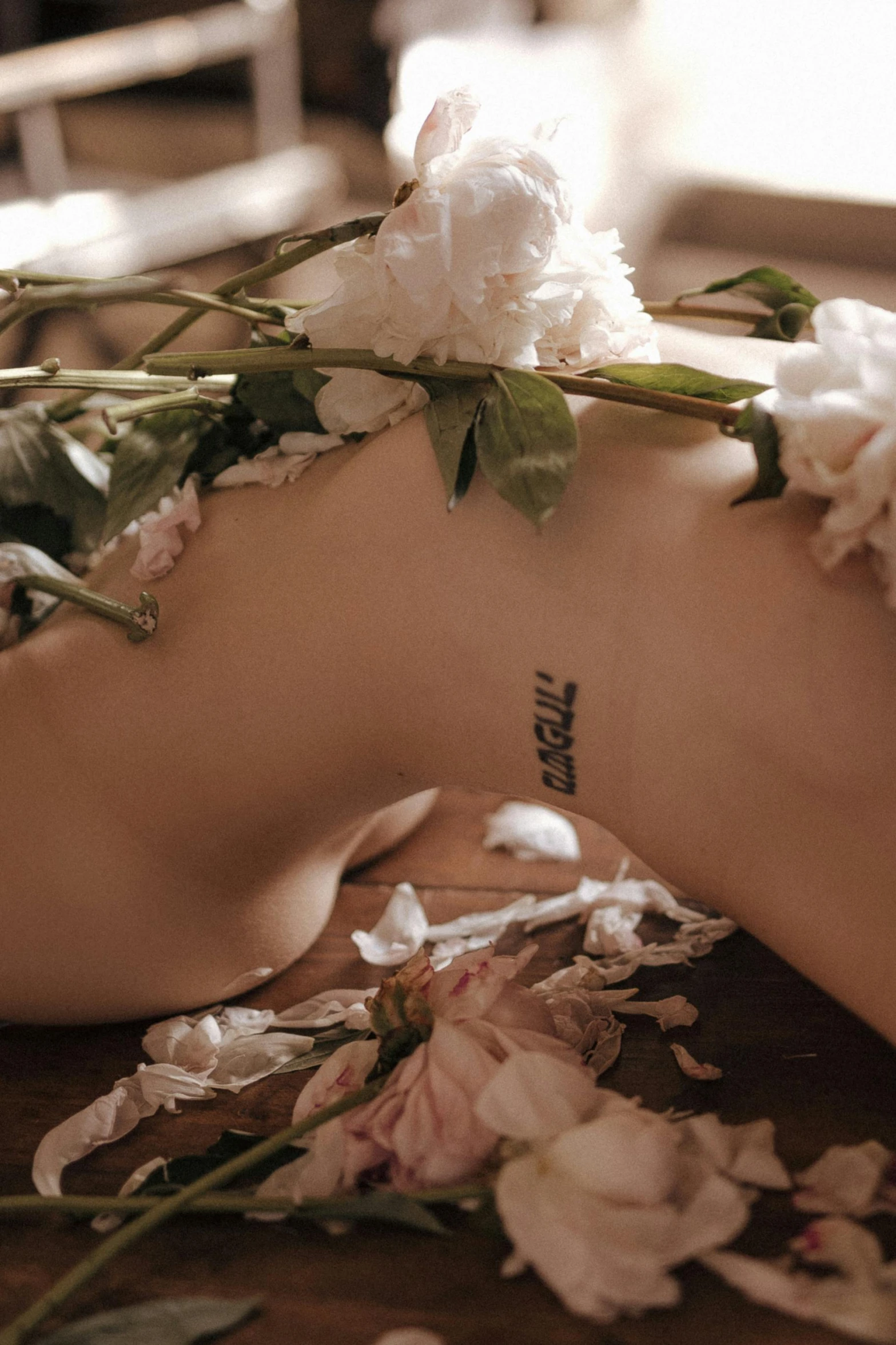 a close up of a person's foot with flowers on it, a tattoo, inspired by Elsa Bleda, aestheticism, a labeled, margiela campaign, arms behind back, she is laying on her back