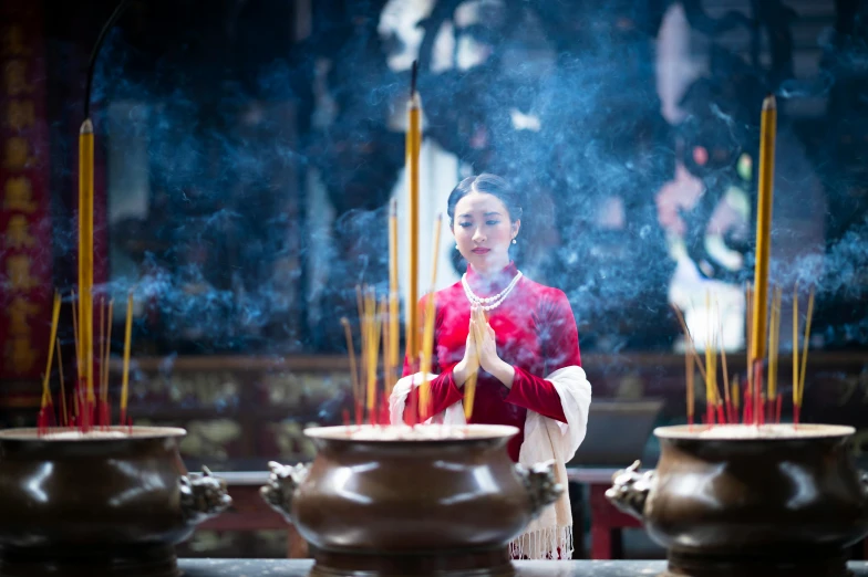 a woman standing in front of a group of incenses, inspired by Hu Zao, avatar image, angel doing yoga in temple, profile image, trending photo