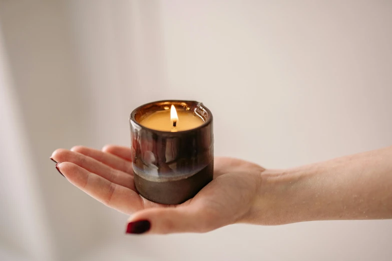 a person holding a candle in their hand, by Nina Hamnett, light and space, handmade pottery, extremely polished, cosy enchanted scene, smoked layered