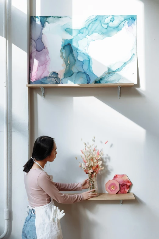 a woman placing flowers in a vase on a shelf, inspired by Kim Tschang Yeul, translucent pastel panels, art installation, swirling scene, product introduction photo