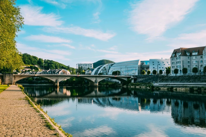 a bridge over a river with buildings in the background, by Julia Pishtar, slovakia, northern france, chesterfield, multiple stories