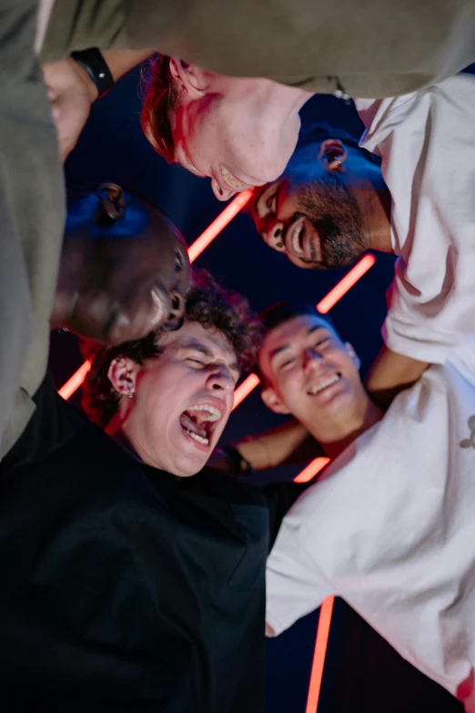 a group of people standing around each other, an album cover, trending on pexels, happening, tickle fight in the death tent, imax close-up of face, in a nightclub, bladee from drain gang