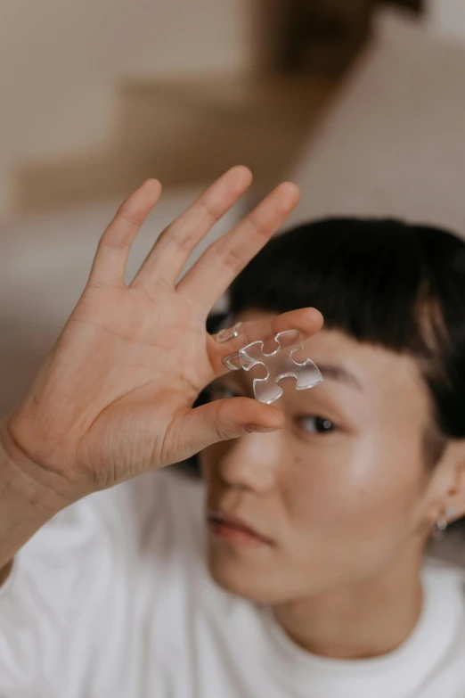 a close up of a person holding something in their hand, by helen huang, glass facial muscles, high forehead, product introduction photo, japanese