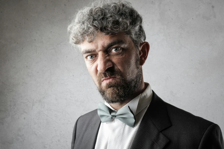 a man with a beard wearing a suit and bow tie, inspired by René Magritte, pexels contest winner, renaissance, silver curly hair, horrified, photograph taken in 2 0 2 0, gray men