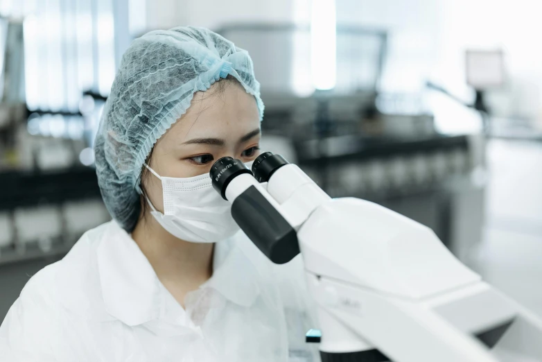 a woman in a lab coat looking through a microscope, whealan, surgical gown and scrubs on, profile image, gemma chen