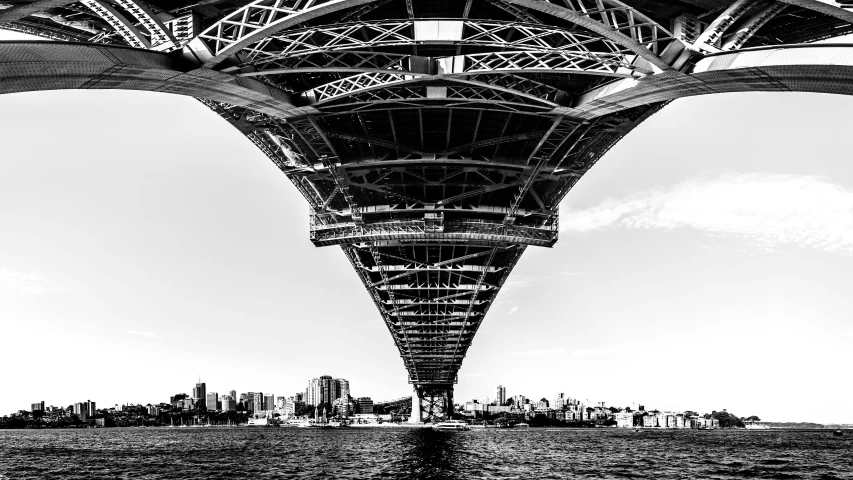 a black and white photo of the underside of a bridge, by Dennis Flanders, unsplash contest winner, sydney, towering over a city, enormous in size, vivid and detailed