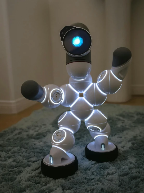 a robot that is sitting on a rug, a hologram, inspired by Oskar Schlemmer, reddit contest winner, kinetic art, dancing lights, y 2 k cutecore clowncore, large led lights, product introduction photo