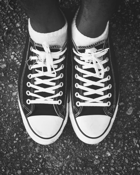 a black and white photo of a pair of sneakers, a black and white photo, by Lucia Peka, pexels, sots art, rock star, staring at you, a tall, 2263539546]