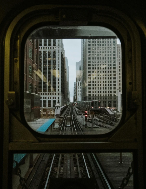 a train traveling through a city next to tall buildings, inspired by Vivian Maier, unsplash contest winner, view through window, chicago, gif, 2 0 2 2 photo