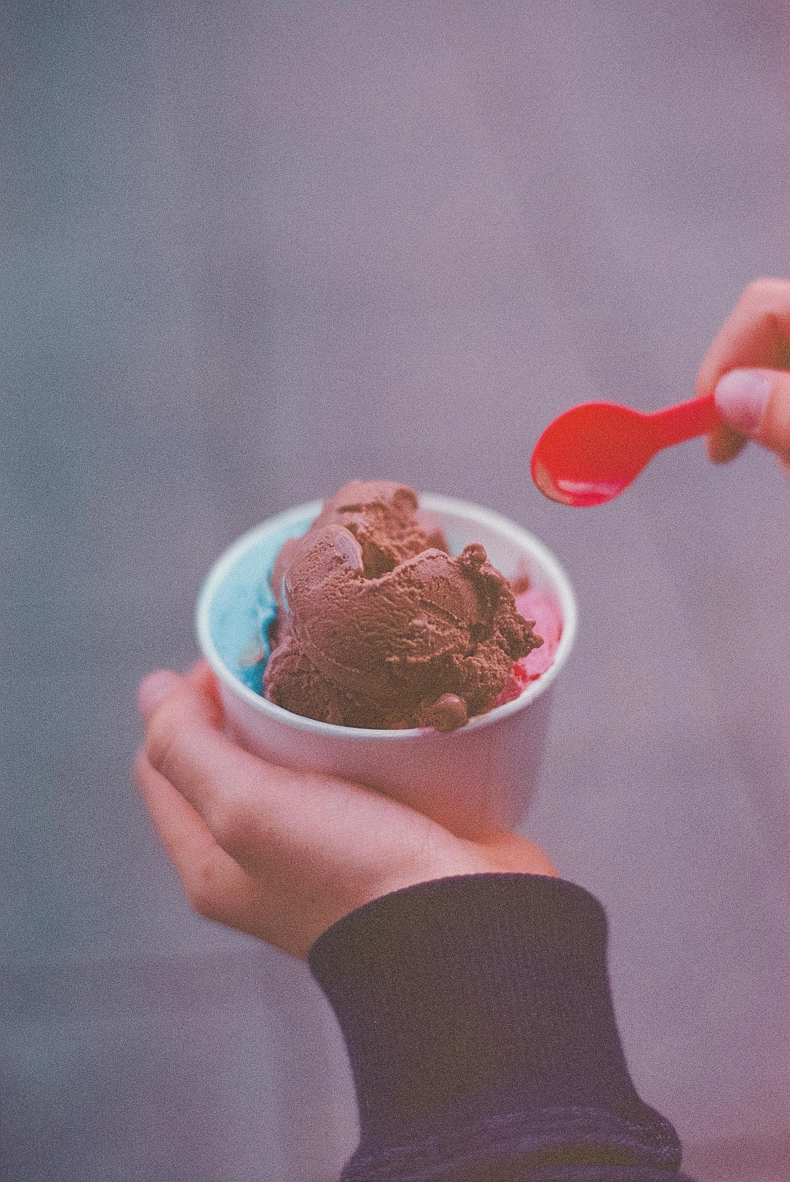 a person holding a bowl of ice cream, inspired by Elsa Bleda, pexels contest winner, brown red blue, vintage soft grainy, made of glazed, pink