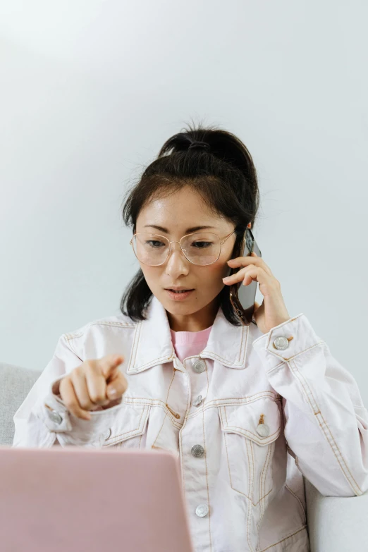 a woman sitting on a couch talking on a cell phone, a cartoon, trending on pexels, star trek asian woman, working in a call center, wearing a light - pink suit, woman in streetwear