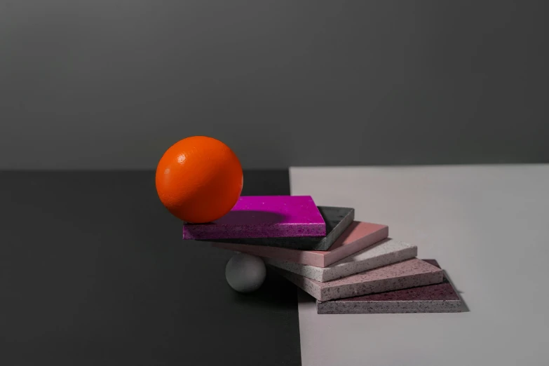 an orange sitting on top of a stack of blocks, an abstract sculpture, inspired by Bauhaus, unsplash contest winner, magenta and gray, paddle and ball, behance lemanoosh, spheres