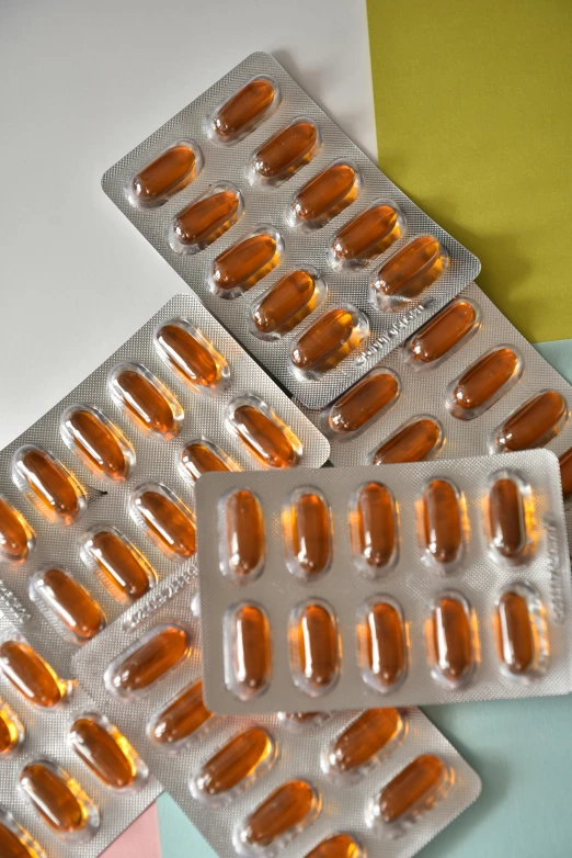 a bunch of pills sitting on top of a table, orange safety labels, fully symmetrical, soft opalescent membranes, aged 2 5