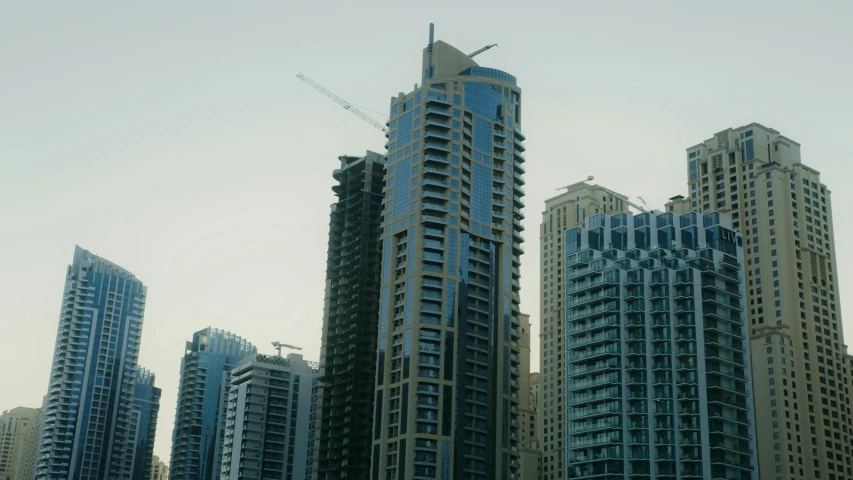 a group of tall buildings sitting next to each other, hurufiyya, gta : dubai, low quality photo, 8k resolution”, construction