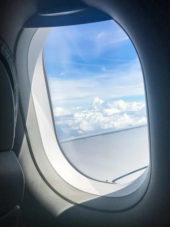 a view of the sky through an airplane window, happening, photo taken in 2 0 2 0, fan favorite, portholes, clouds swirling