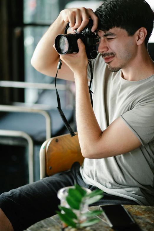 a man sitting in a chair holding a camera