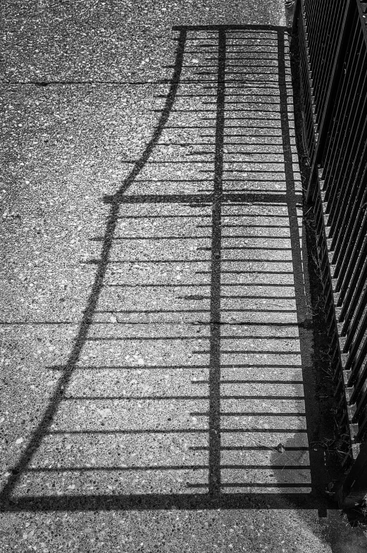 a black and white photo of a fence and a fire hydrant, inspired by Louis Stettner, postminimalism, long cast shadows, ( ( abstract ) ), made of wrought iron, location [ chicago ( alley ) ]