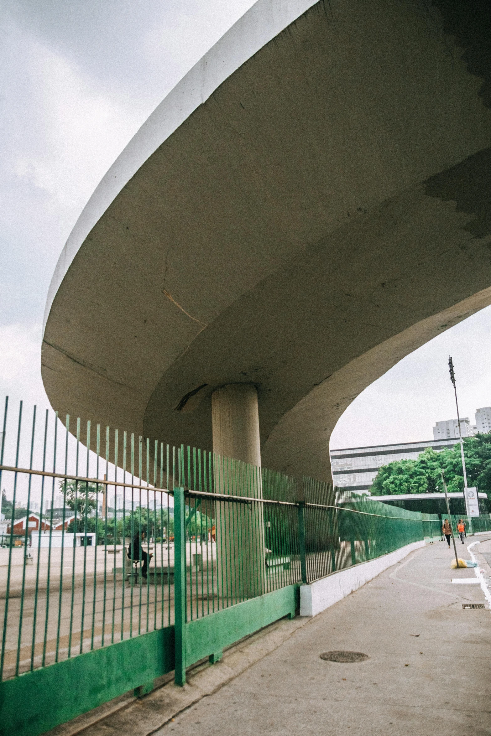 a man riding a skateboard up the side of a ramp, inspired by Zha Shibiao, unsplash, brutalism, manila, monorail station, rounded roof, highway